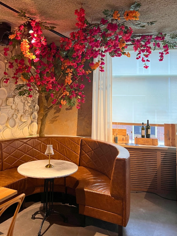Elegante kunst bloesemboom geplaatst in een restaurant, perfect voor het toevoegen van een sfeervolle, natuurlijke uitstraling