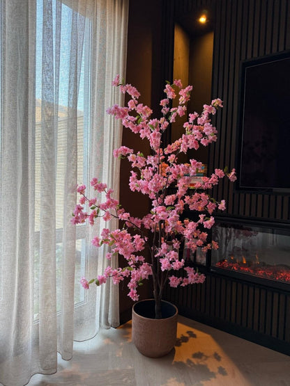 Roze bloesemboom in een woonkamer uitgezoomd